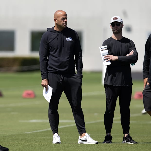 San Francisco 49ers defensive coordinator Robert Saleh (second from left) watches his players work out during a team OTA.