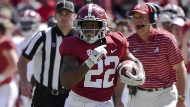 Alabama Crimson Tide running back Justice Haynes on a rushing attempt during a college football game in the SEC.
