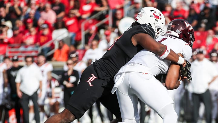 Louisville Cardinals defensive lineman Ramon Puryear (41) sacks Virginia Tech Hokies quarterback Kyron Drones (1) as the Cards went up against Virginia Tech Saturday in the second quarter.