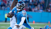 Tennessee quarterback Cam Ward (1) runs against Houston defensive tackle Mario Edwards Jr. (97) late in the fourth quarter during their game at Nissan Stadium in Nashville, Tenn., Sunday, Nov. 16, 2025. The Titans scored a touchdown on the next play and tied the game with a Tennessee place kicker Joey Slye (6) extra point. With about 1:30 to go in the game, Houston moved down the field and kicked a game-winning field goal to run out the clock. The final score: Texans 16 - Titans 13.