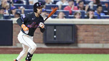 Jul 2, 2025; New York City, New York, USA;  New York Mets designated hitter Francisco Lindor (12) hits an RBI double in the eighth inning against the Milwaukee Brewers at Citi Field. Mandatory Credit: Wendell Cruz-Imagn Images