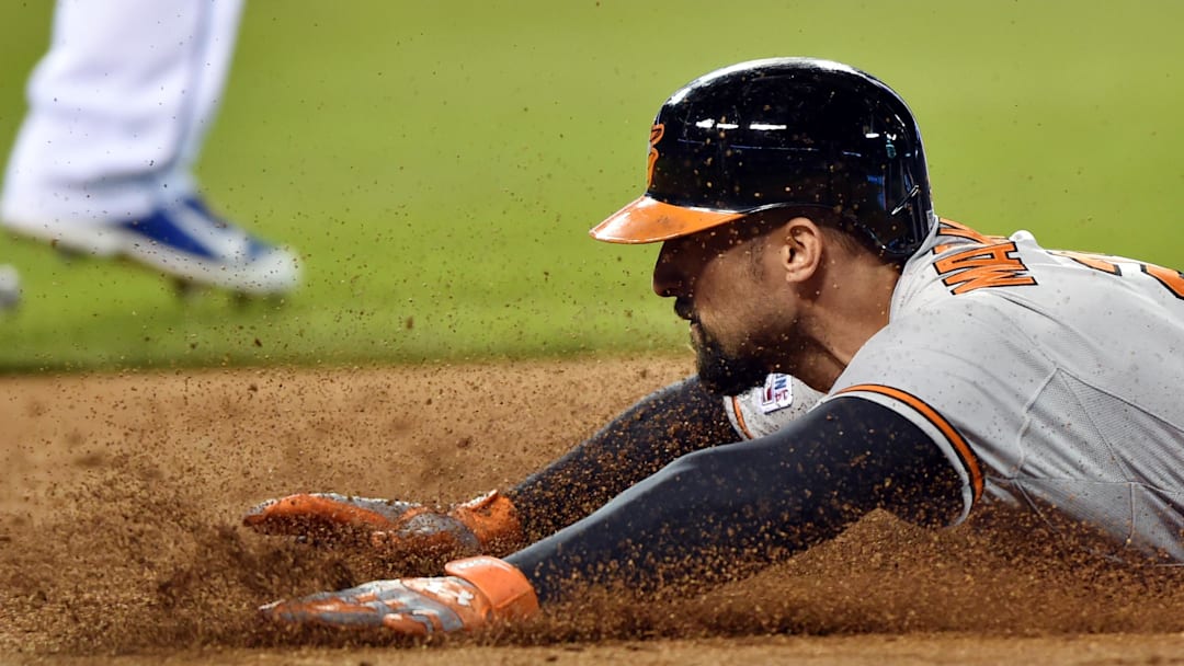 Oct 14, 2014; Kansas City, MO, USA; Baltimore Orioles right fielder Nick Markakis dives back to first base safely on a fielder's choice against the Kansas City Royals during the third inning in game three of the 2014 ALCS playoff baseball game at Kauffman Stadium. Mandatory Credit: Peter G. Aiken-Imagn Images