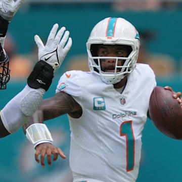 Miami Dolphins quarterback Tua Tagovailoa (1) rolls out to pass as linebacker Foyesade Oluokun (23) follows on the play at Hard Rock Stadium.