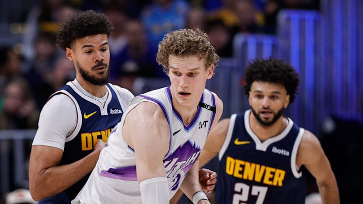 Dec 22, 2025; Denver, Colorado, USA; Utah Jazz forward Lauri Markkanen (23) controls the ball under pressure from Denver Nuggets forward Cameron Johnson (23) as guard Jamal Murray (27) defends in the third quarter at Ball Arena. Mandatory Credit: Isaiah J. Downing-Imagn Images