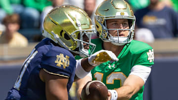Notre Dame Fighting Irish quarterback CJ Carr (right) hands off to running back Kedren Young (left)  during the Blue-Gold game