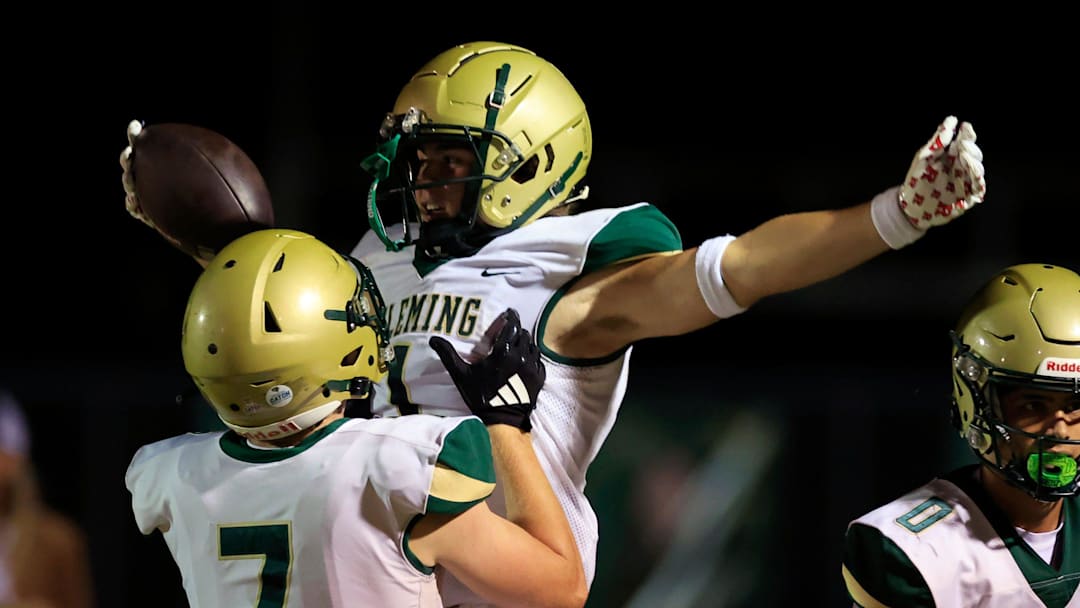 Fleming Island's Parker Sirdevan (7) lifts Sebastian Cruz (1) after Cruz’s touchdown score during the third quarter of a high school football matchup at Fleming Island High School, Friday, Oct. 24, 2025, in Fleming Island, Fla. The Fleming Island Golden Eagles defeated the Middleburg Broncos 21-10.