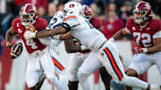 Alabama Crimson Tide quarterback Jalen Milroe (4) fumbles the ball while pressured by Auburn Tigers defensive lineman Keldric Faulk (15) as Auburn Tigers take on Alabama Crimson Tide at Bryant-Denny Stadium in Tuscaloosa, Ala., on Saturday, Nov. 30, 2024. Alabama Crimson Tide leads Auburn Tigers 14-6 at halftime.