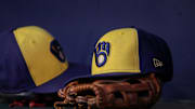 A detailed view of a Milwaukee Brewers hat and glove on the bench against the Atlanta Braves in the second inning at Truist Park in 2023.