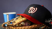 Sep 29, 2023; Atlanta, Georgia, USA; A detailed view of a Washington Nationals hat and glove on the bench against the Atlanta Braves in the third inning at Truist Park. 