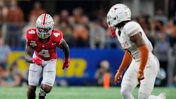 Ohio State Buckeyes wide receiver Jeremiah Smith (4) tries to get open against Texas Longhorns defensive back Jahdae Barron (7) in the fourth quarter of the Cotton Bowl Classic during the College Football Playoff semifinal game at AT&T Stadium in Arlington, Texas on January, 10, 2025.