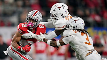Ohio State Buckeyes wide receiver Emeka Egbuka (2) makes a catch against Texas Longhorns defensive back Jaylon Guilbeau (3) and linebacker Anthony Hill Jr. (0) in the first quarter of the Cotton Bowl Classic during the College Football Playoff semifinal game at AT&T Stadium in Arlington, Texas on January, 10, 2025.
