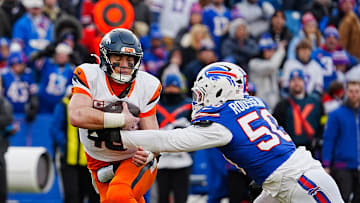 Denver Broncos quarterback Bo Nix gets grabbed by and then sacked by Buffalo Bills defensive end Greg Rousseau during the second half of the Buffalo Bills wild card game against the Denver Broncos at Highmark Stadium in Orchard Park on Jan. 12, 2025.