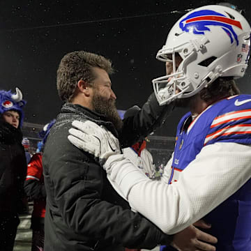 Buffalo Bills quarterback Josh Allen comes to the sideline to greet former Bills quarterback Ryan Fitzpatrick during warm ups before the Buffalo Bills divisional game against the Baltimore Ravens at Highmark Stadium in Orchard Park on Jan. 19, 2025.