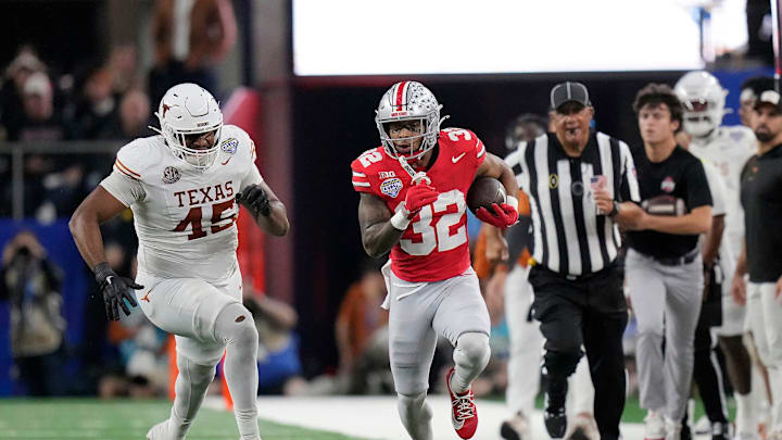Ohio State Buckeyes running back TreVeyon Henderson (32) gets away from Texas Longhorns defensive lineman Vernon Broughton (45) on run in the first quarter of the Cotton Bowl Classic during the College Football Playoff semifinal game at AT&T Stadium in Arlington, Texas on January, 10, 2025.