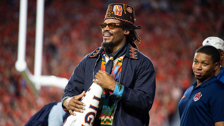 Former Auburn quarterback Cam Newton cheers on his team from the sideline as Auburn Tigers take on Georgia Bulldogs at Jordan-Hare Stadium in Auburn, Ala. on Saturday, Oct. 11, 2025. Auburn Tigers lead Georgia Bulldogs 10-3 at halftime.