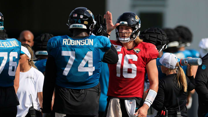 Jacksonville Jaguars quarterback Trevor Lawrence (16) high-fives offensive tackle Cam Robinson (74) during the seventh day of an NFL football training camp practice Wednesday, July 31, 2024 at EverBank Stadium’s Miller Electric Center in Jacksonville, Fla.