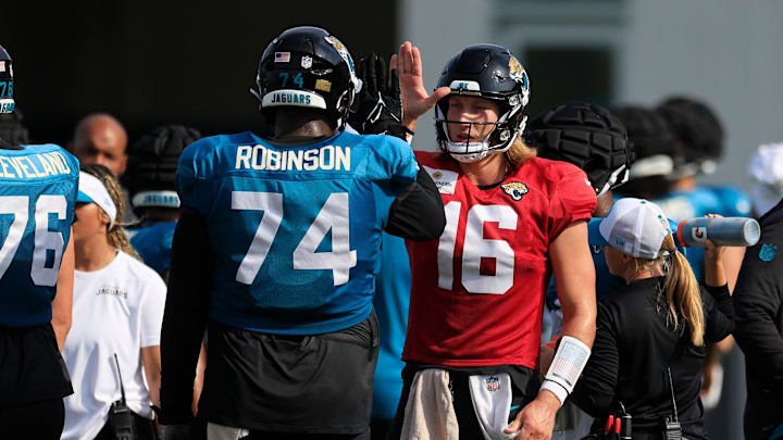 Jacksonville Jaguars quarterback Trevor Lawrence (16) high-fives offensive tackle Cam Robinson (74) during the seventh day of an NFL football training camp practice Wednesday, July 31, 2024 at EverBank Stadium’s Miller Electric Center in Jacksonville, Fla.