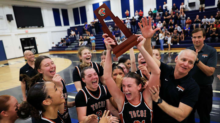 Tocoi Creek's Audrey Beyer (21) holds upt he trophy celebrating with teammates after the game of the District 3-6A girls basketball final Friday, Feb. 7, 2025 at Bartram Trail High School in St. Johns, Fla. The Tocoi Creek Toros defeated the Bartram Trail Bears 52-37. Tocoi Creek's Audrey Beyer (21) holds upt he trophy celebrating with teammates after the game of the District 3-6A girls basketball final Friday, Feb. 7, 2025 at Bartram Trail High School in St. Johns, Fla. The Tocoi Creek Toros defeated the Bartram Trail Bears 52-37.