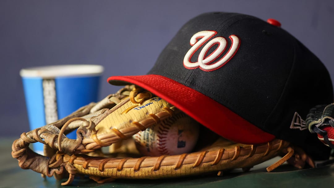 Sep 29, 2023; Atlanta, Georgia, USA; A detailed view of a Washington Nationals hat and glove on the bench against the Atlanta Braves in the third inning at Truist Park.