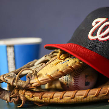 Sep 29, 2023; Atlanta, Georgia, USA; A detailed view of a Washington Nationals hat and glove on the bench against the Atlanta Braves in the third inning at Truist Park. Mandatory Credit: Brett Davis-Imagn Images