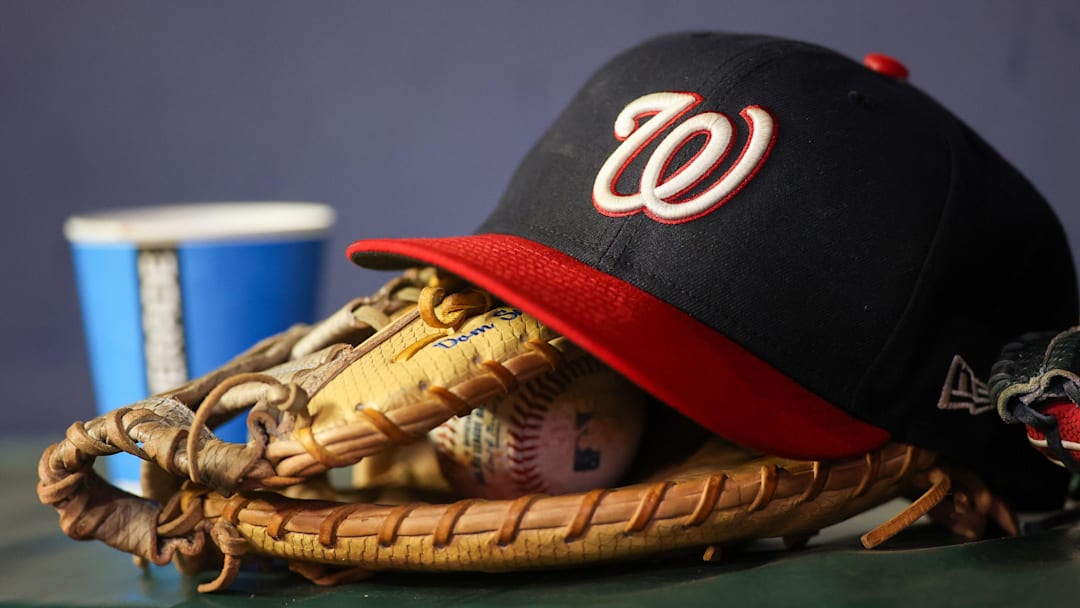 Sep 29, 2023; Atlanta, Georgia, USA; A detailed view of a Washington Nationals hat and glove on the bench against the Atlanta Braves in the third inning at Truist Park.