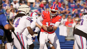 Buffalo Bills quarterback Josh Allen hands the ball off to running back James Cook during the NFL training camp practice