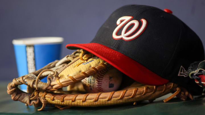 A detailed view of a Washington Nationals hat and glove on the bench