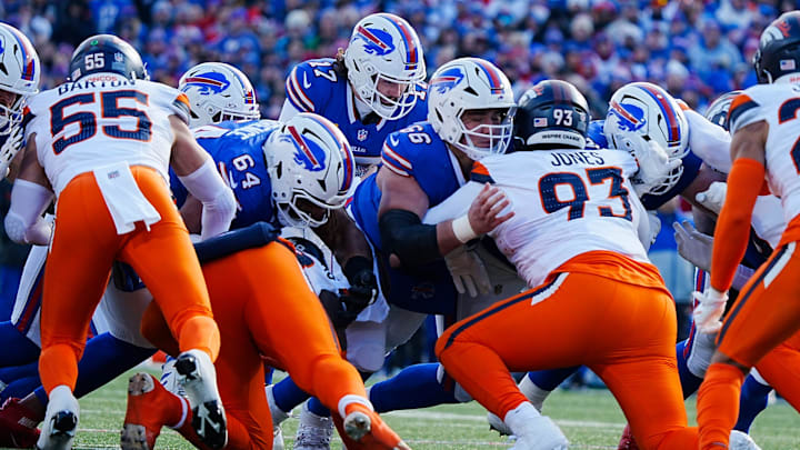Buffalo Bills quarterback Josh Allen carries the ball across the line of scrimmage for a first down.