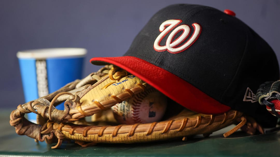 Dark blue Washington Nationals hat on top of a light brown mitt