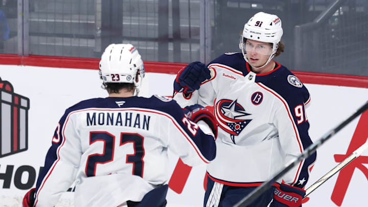 Blue Jackets forwards Sean Monahan and Kent Johnson celebrate a goal. Now full-time linemates, they need some help. 
