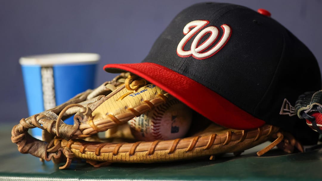 Dark blue Washington Nationals hat on top of a light brown mitt