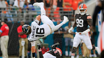 Jacksonville Jaguars quarterback Trevor Lawrence (16) is upended by Cleveland Browns linebacker Jeremiah Owusu-Koramoah (6) as defensive end Za'Darius Smith (99) looks on during the fourth quarter of an NFL football matchup Sunday, Sept. 15, 2024 at EverBank Stadium in Jacksonville, Fla. 