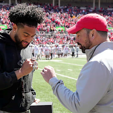 Ohio State Buckeyes head coach Ryan Day talks about the championship ring to former Buckeye JT Tuimoloau after he received a box of three rings for winning the College Football Playoffs during the spring game at Ohio Stadium on April 12, 2025. Players and coaches from the 2024 championship team received a ring for making the College Football Playoff, one from the CFP for winning it and a championship ring from Ohio State.