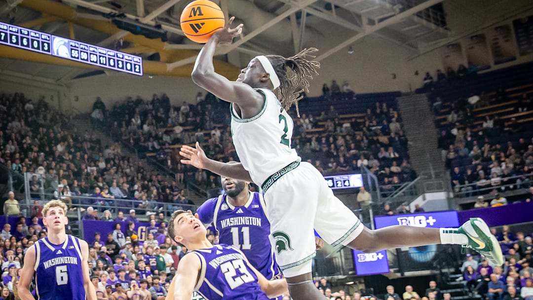 Michigan State's Kur Teng bowls over the UW's JJ Mandaquit on his way to the basket. 