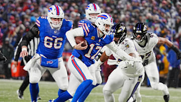 Buffalo Bills quarterback Josh Allen runs with the ball trying to avoid the reach of Baltimore Ravens defensive tackle Nnamdi Madubuike during first half action during the Buffalo Bills divisional game against the Baltimore Ravens at Highmark Stadium in Orchard Park on Jan. 19, 2025.