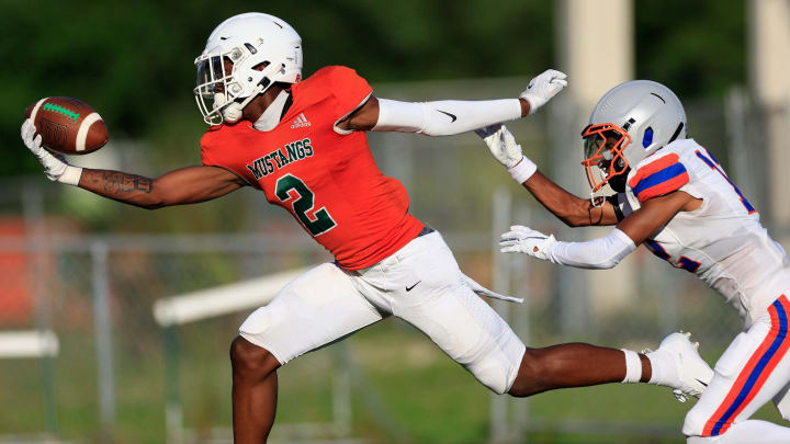 Mandarin's Jaime Ffrench (2) makes a one-handed touchdown reception against Bolles' Santana Starks (12) during the first quarter of a high school football matchup Thursday, May 23, 2024 at Mandarin High School in Jacksonville, Fla. Mandarin defeated Bolles 35-14.