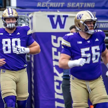 Zach Henning, wearing a tight-end jersey, is flanked by Hatchetts. 