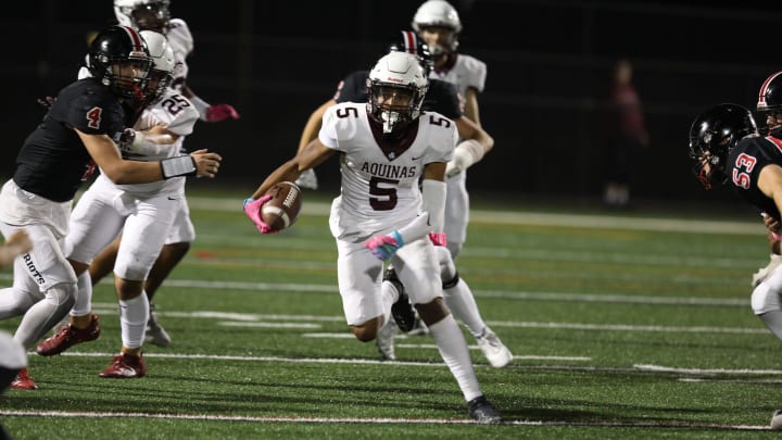 Aquinas Derrion Battle finds an open lane to run through for a gain of several yards. Battle scored his team's first touchdown early in the first quarter.