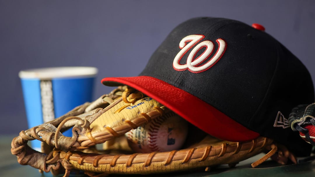 Sep 29, 2023; Atlanta, Georgia, USA; A detailed view of a Washington Nationals hat and glove on the bench against the Atlanta Braves in the third inning at Truist Park. 