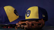 Jul 28, 2023; Atlanta, Georgia, USA; A detailed view of a Milwaukee Brewers hat and glove on the bench against the Atlanta Braves in the second inning at Truist Park. Mandatory Credit: Brett Davis-Imagn Images