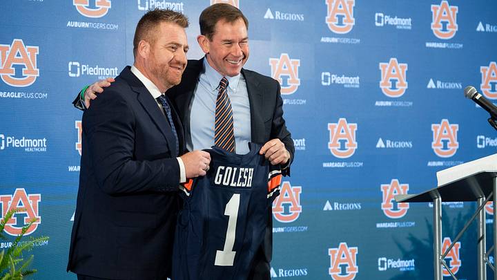 Auburn football head coach Alex Golesh and Auburn athletic director John Cohen pose for photos during his introductory press conference at Jordan-Hare Stadium in Auburn, Ala. on Monday, Dec. 1, 2025.
