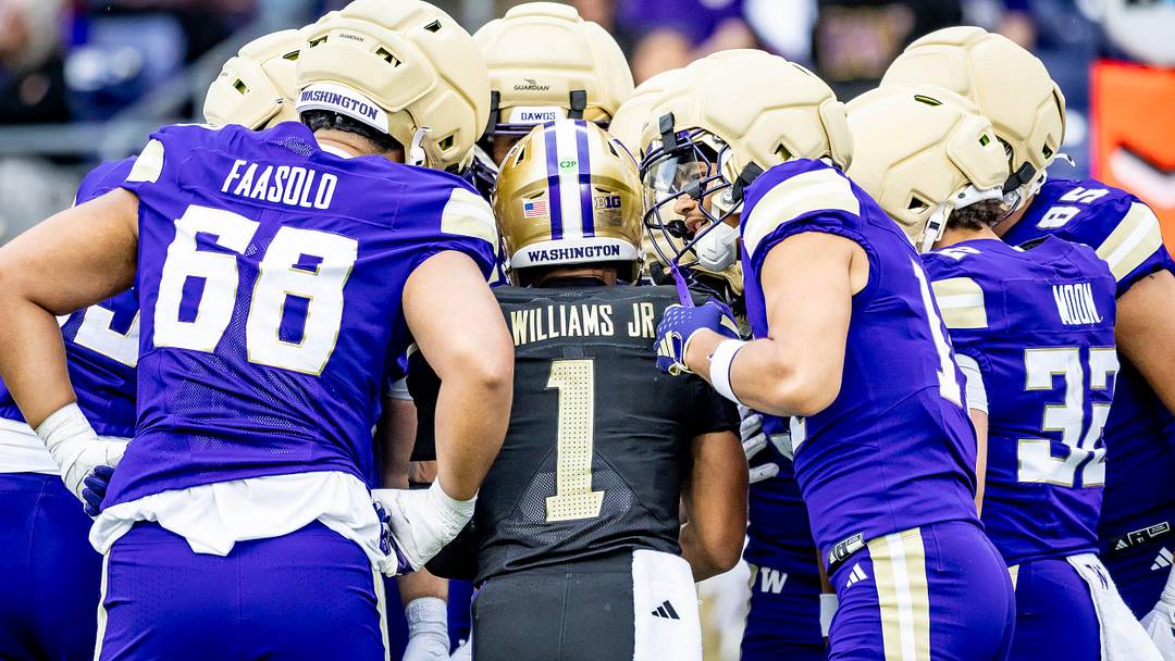 The Huskies crowd around Demond Williams Jr. as he calls a Spring Game play. 