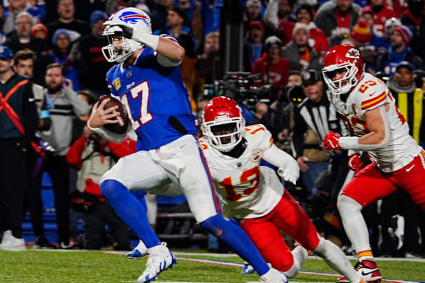 Buffalo Bills quarterback Josh Allen eludes two Kansas City Chiefs defenders.