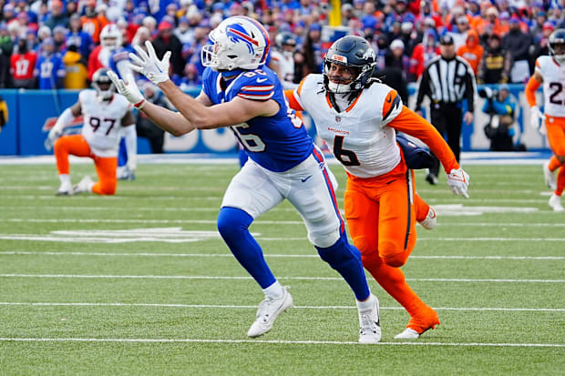 Buffalo Bills tight end Dalton Kincaid catches pass with trailing Denver Broncos defender.