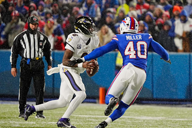 Baltimore Ravens quarterback Lamar Jackson scrambles looking for a player to pass to as Buffalo Bills linebacker Von Miller