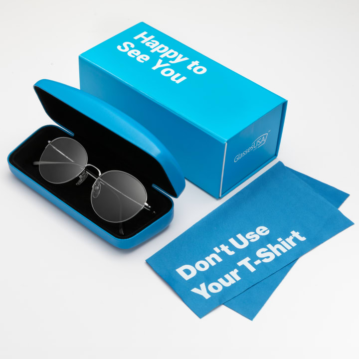 Blue box that says "Happy to see you" on a white background next to a pair of glasses in a case