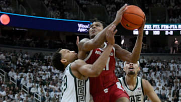 Nov 8, 2025; East Lansing, Michigan, USA;  Michigan State Spartans guard Divine Ugochukwu (99) defends Arkansas Razorbacks forward Karter Knox (11) during the first half at Jack Breslin Student Events Center. Mandatory Credit: Dale Young-Imagn Images
