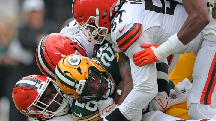 Green Bay Packers running back AJ Dillon (28) is brought down by a host of Cleveland Browns defenders during the first half of an NFL preseason football game at Cleveland Browns Stadium, Saturday, Aug. 10, 2024, in Cleveland, Ohio.