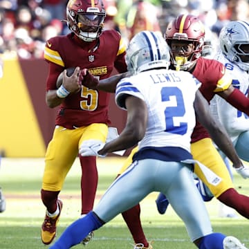 Washington Commanders quarterback Jayden Daniels runs with the ball as Dallas Cowboys corner Jourdam Lewis