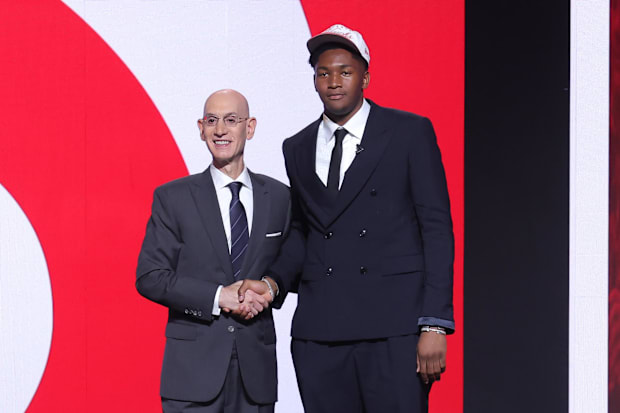 Derik Queen stands with the NBA commissioner Adam Silver